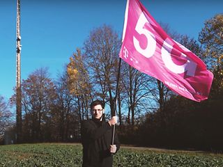 Mann schwenkt Fahne auf einem Acker