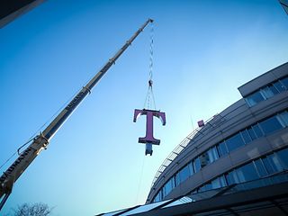 Ein Kran befördert das 1,5 Tonnen schwere T auf das Dach der Konzernzentrale.