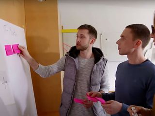 3 people with post-its in front of a whiteboard