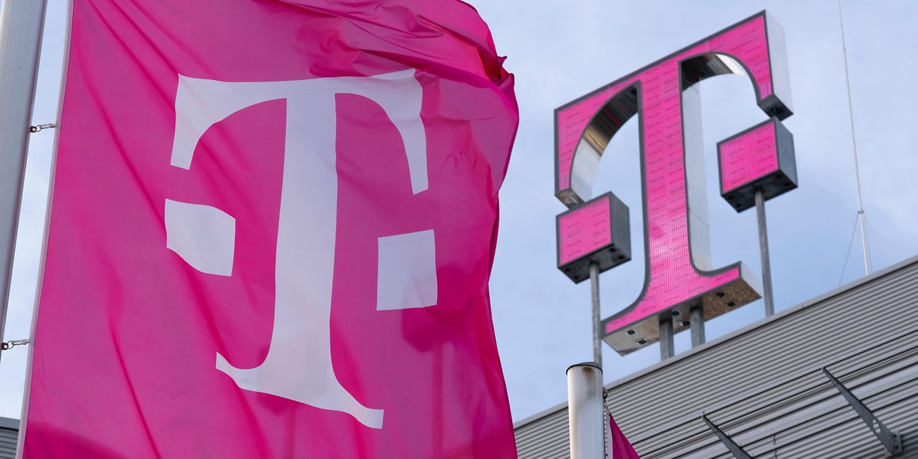 Telekom Logo auf dem Dach mit Flaggen im Vordergrund.