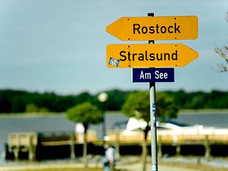 Wegweiser mit Pfeilen nach Stralsund und Rostock. 