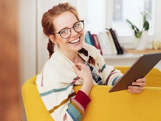 Frau mit Tablet im Sessel