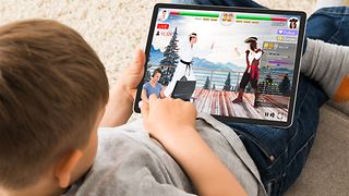 Child is playing on its tablet.
