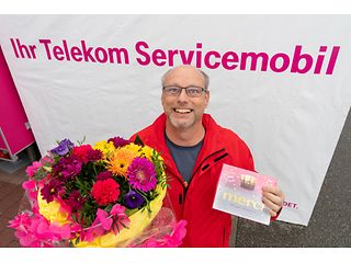 Der 500. Servicemobil-Kunde freut sich über Blumen und Schokolade. 