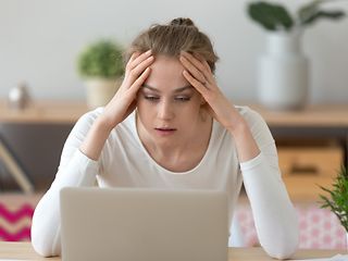 Frau sitzt entsetzt vor ihrem Laptop