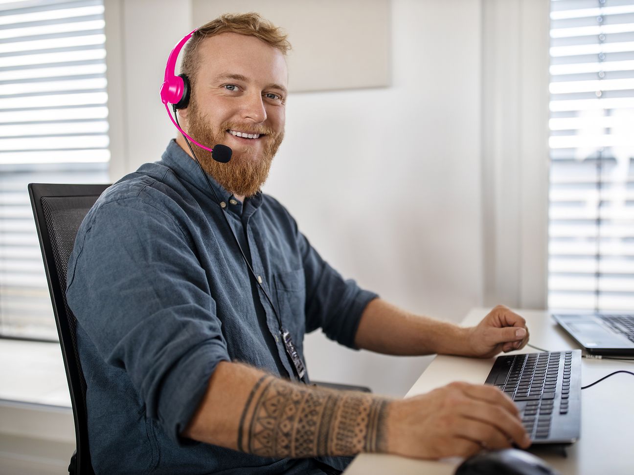 Mann mit Headset am Schreibtisch