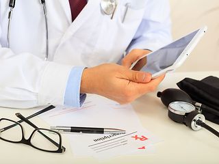 A doctor holds a tablet in his hands