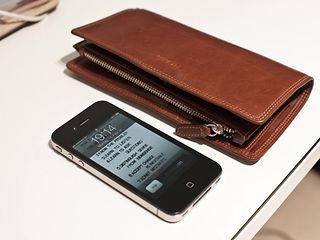 Ein iPhone liegt neben einer Geldbörse