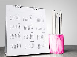 Next to a calendar is a magenta pen holder 