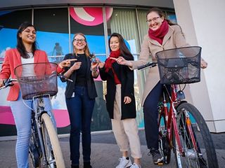 Vier Frauen stehen zusammen und freuen sich über ihr innovatives Produkt: den Fahrradtracker.