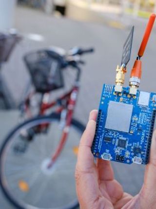 The prototype of the bike tracker is presented and held in the hand.
