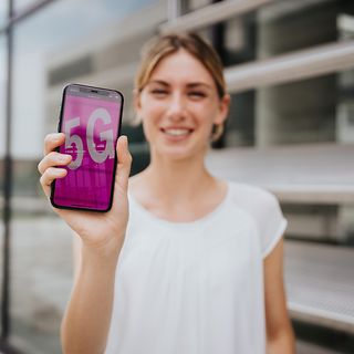 Woman holding a Smartphone. "5G" on display