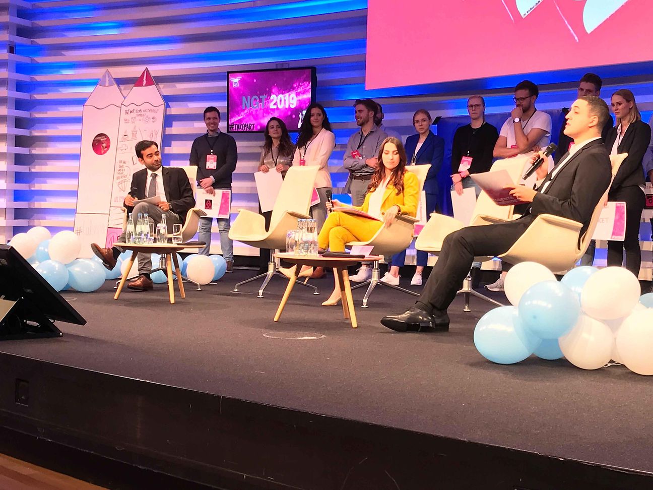 Eine Gruppe junger NGT-Teilnehmer sitzt auf dem Podium und diskutiert