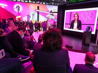 Dominique Leroy auf dem Bildschirm am Telekom-Stand
