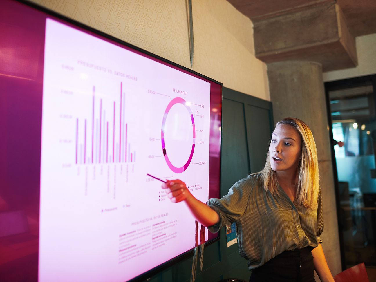 Frau steht vor digitalem Board und erklärt ein Diagramm.