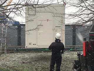 Ein Techniker steht vor einem großen Container.