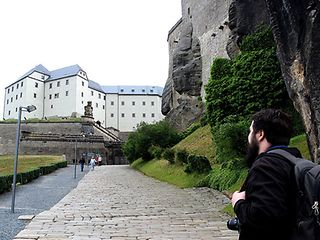 Ein Mann blickt auf ein altes Schloss.