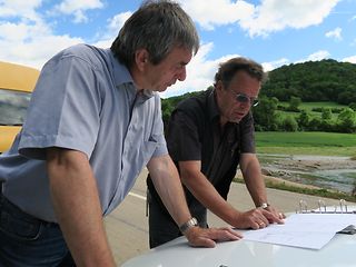 Teamleiter Dieter Rummler und Mess-Techniker Heribert Hanselmann betrachten einen Plan.