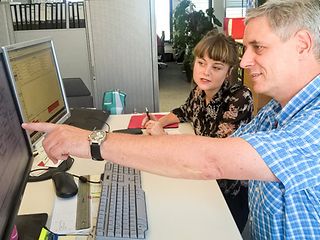 Ein Mann zeigt einer Frau etwas am Computer.