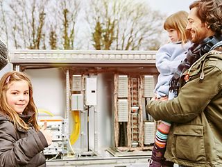 Eine Familie vor einem Offenen Verteilerkasten.