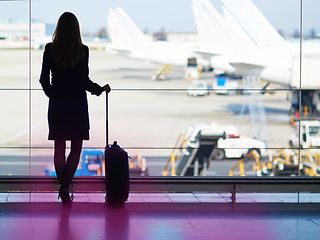 Silhouette von Frau mit Koffer am Flughafen